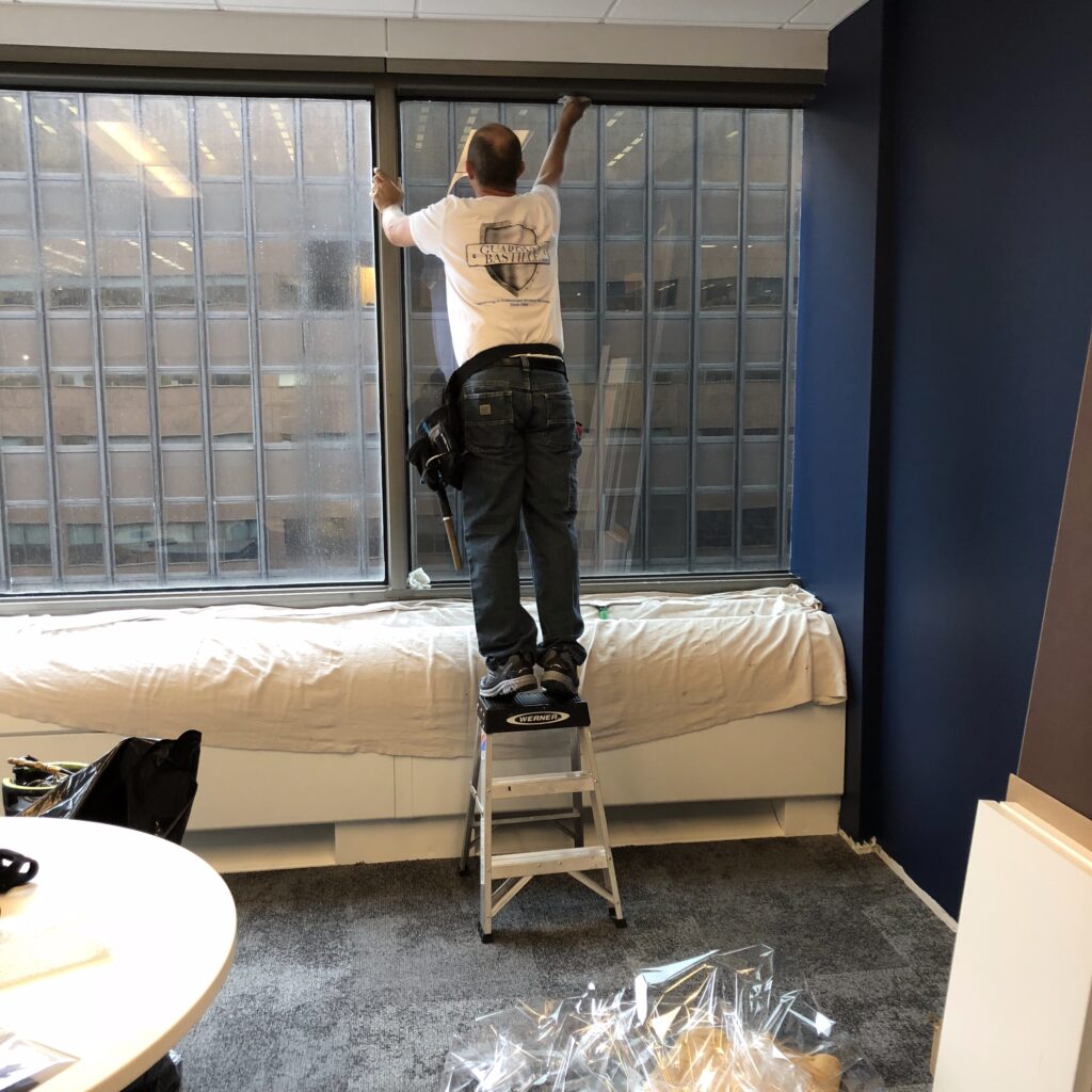 Removing old window film and replacing it with high-performance solar control film at the Federal Reserve Bank, Philadelphia.