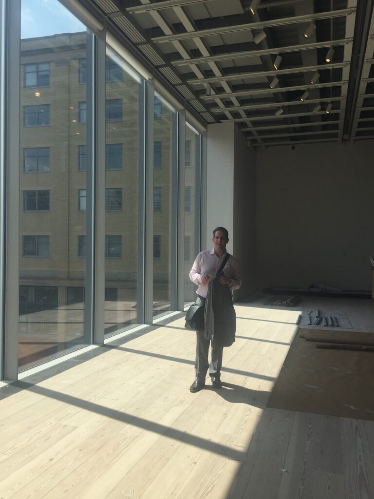 Guardian Bastille President Nick DeCarlo stands beside 18-foot windows during a Whitney Museum installation in NYC.