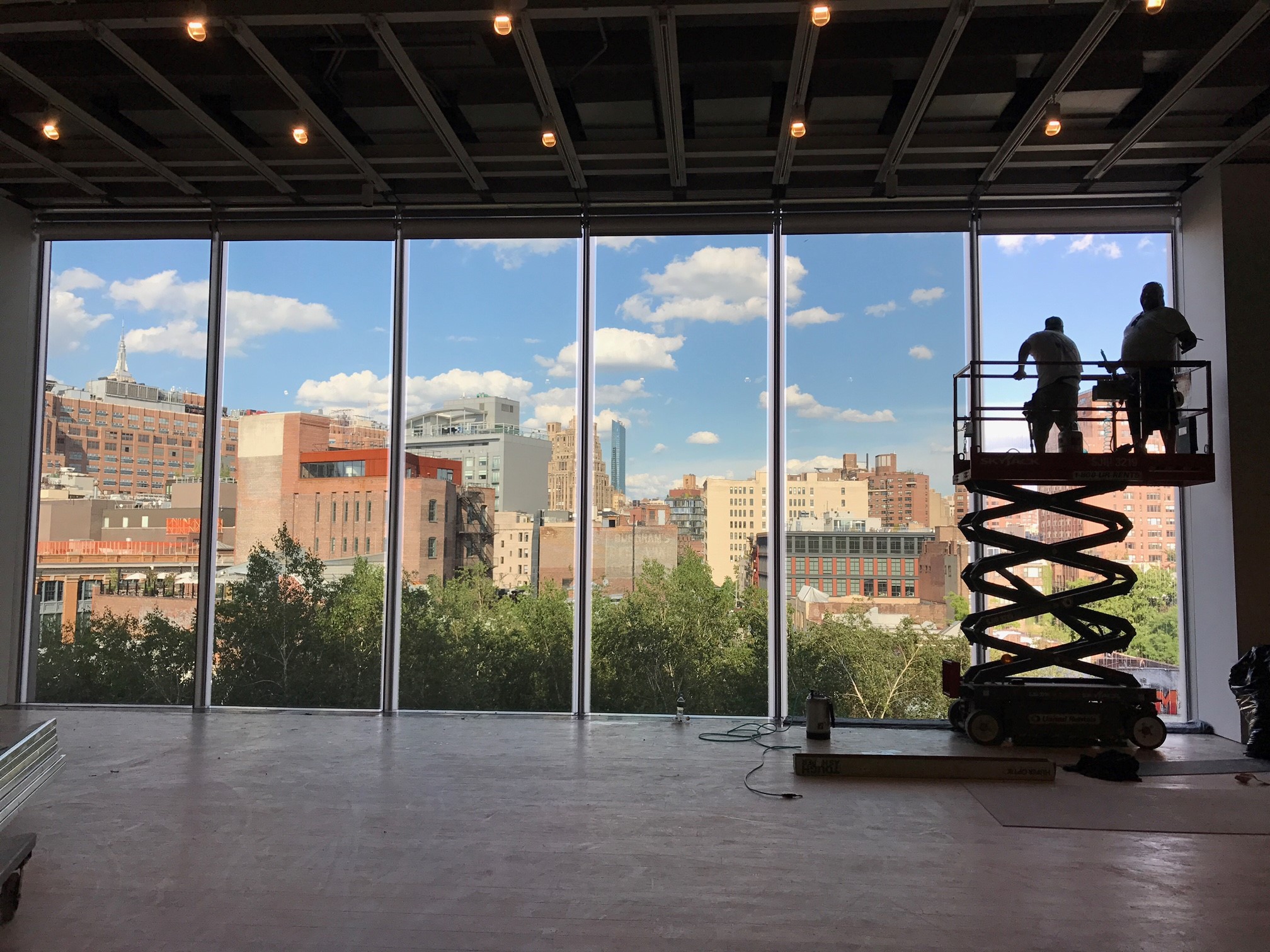 Technicians installing 3M Prestige window film from a lift inside the main gallery of the Whitney Museum in New York City.