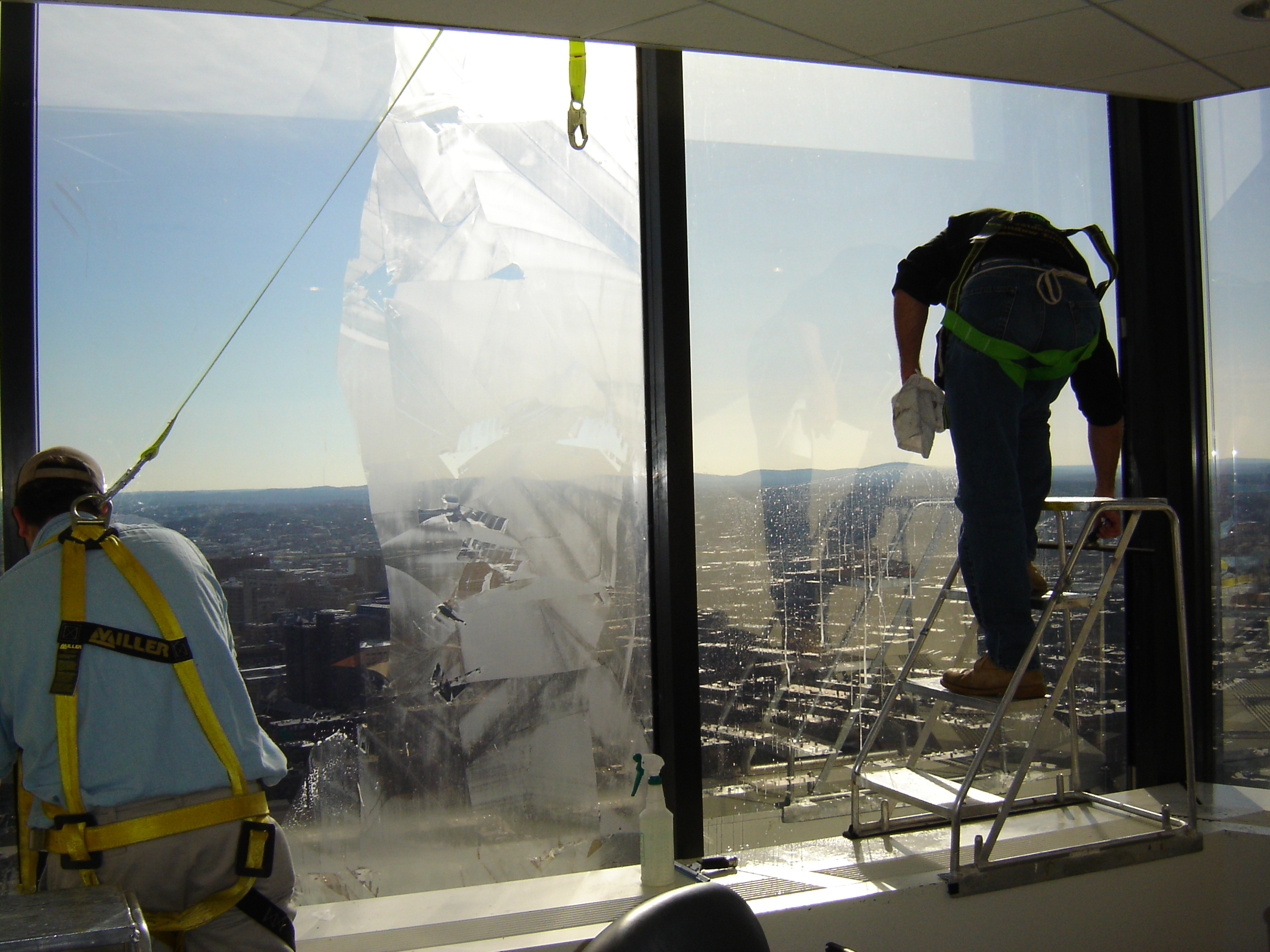 Technicians applying window film to glass at the John Hancock Tower, Boston