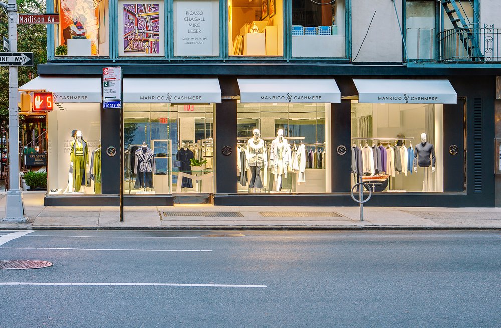 Manrico Cashmere storefront windows on Madison Avenue, New York, NY, lit at dusk