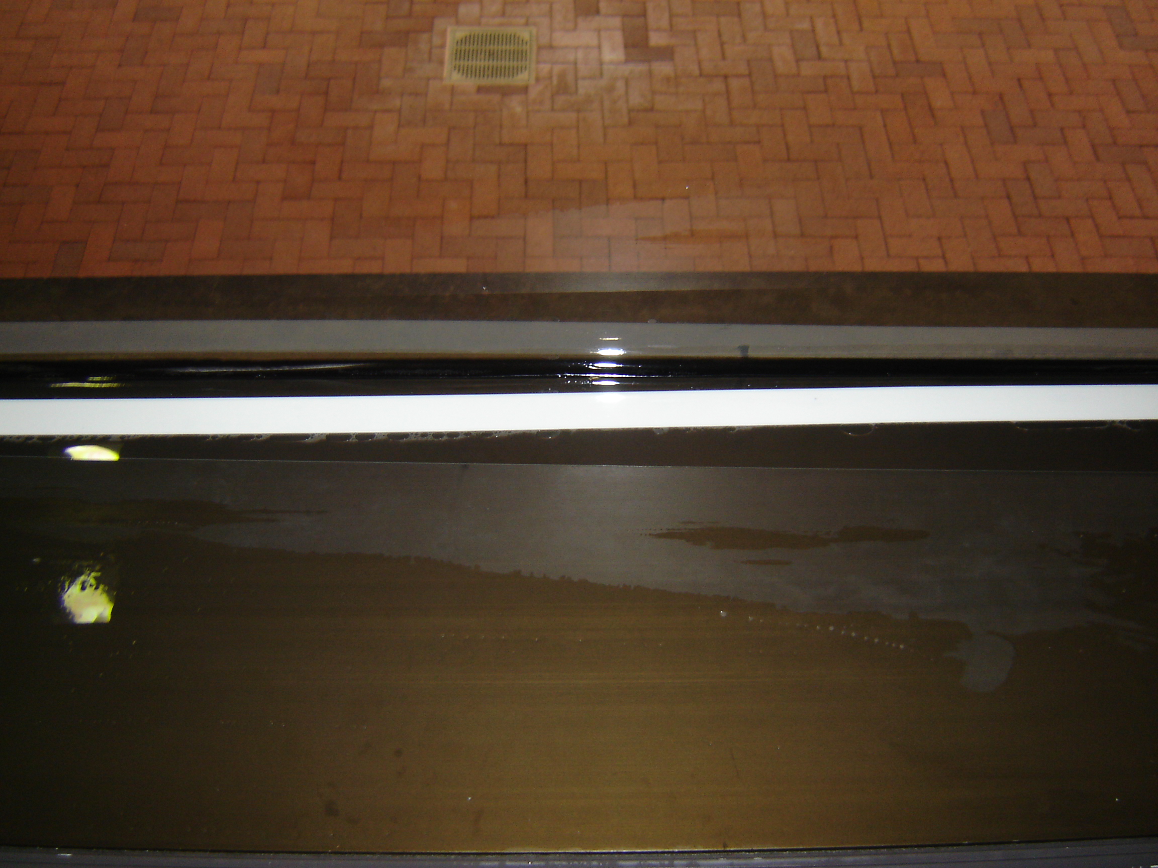 Close-up of the mechanical batten bar securing blast-resistant window film at the McCormack Building