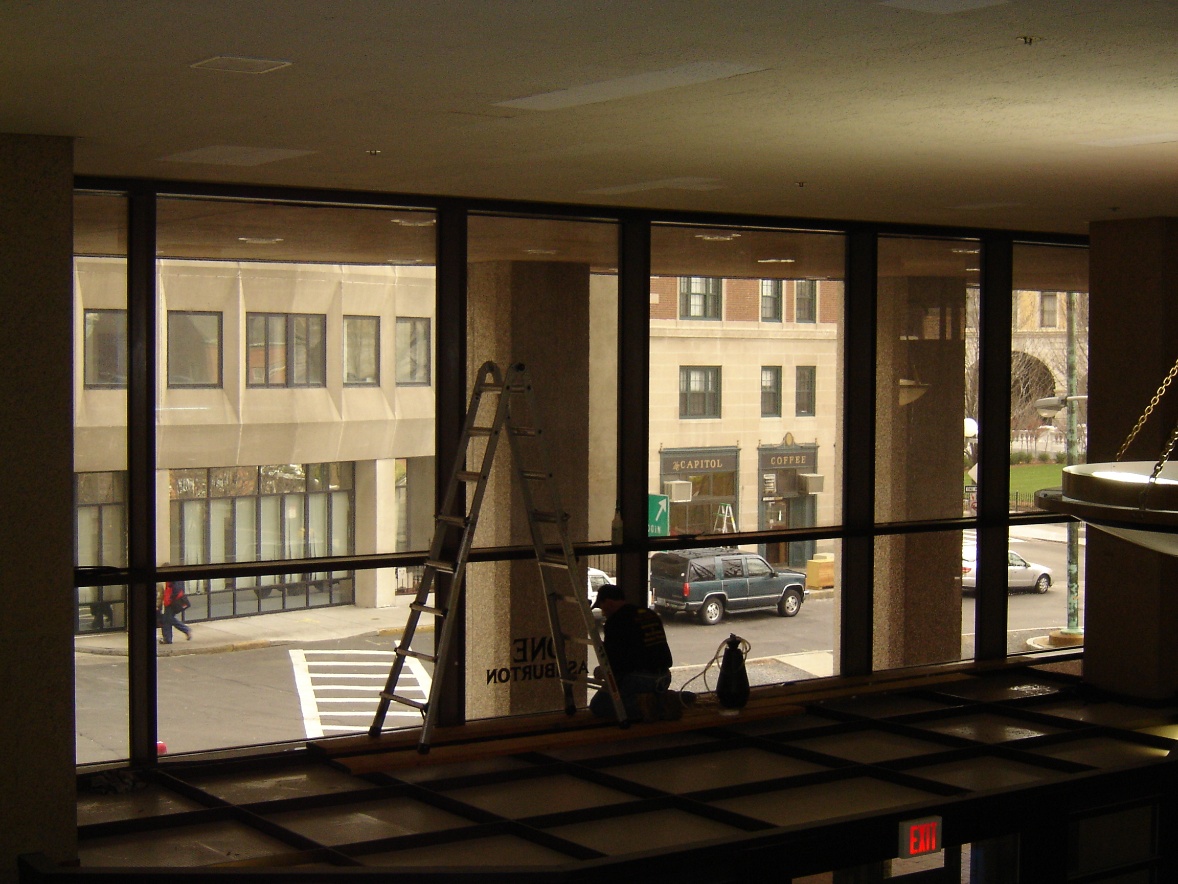 Guardian Bastille technician installing blast-resistant film in the McCormack Building lobby, Boston