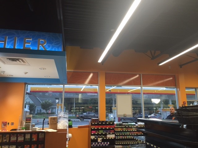 Interior view of a Shell retail service station showing merchandise near solar-filmed storefront glass